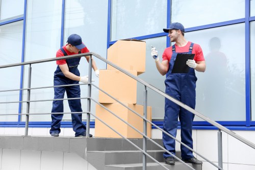 Professional movers unloading items at a residential property in Hire
