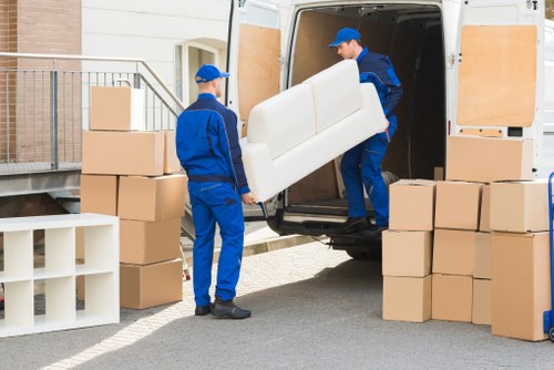 Professional house removals team handling boxes and furniture in Hire